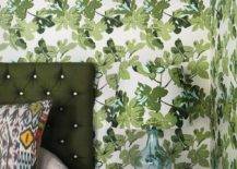 Peter Dunham Fig Leaf wallpaper covers the walls of this beautiful green bedding featuring a bed with a green tufted headboard.