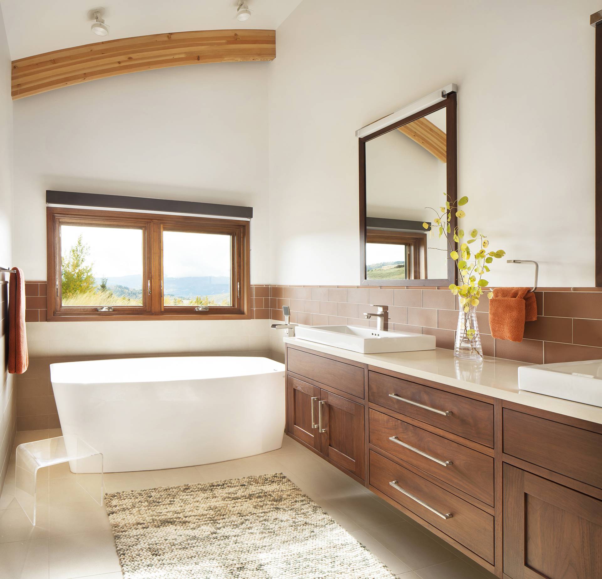 wood and white bathroom with free standing tub, floating counter and double sink