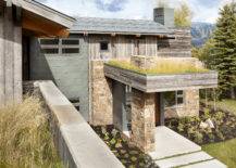 stone overhang and living roof over front entrance of home