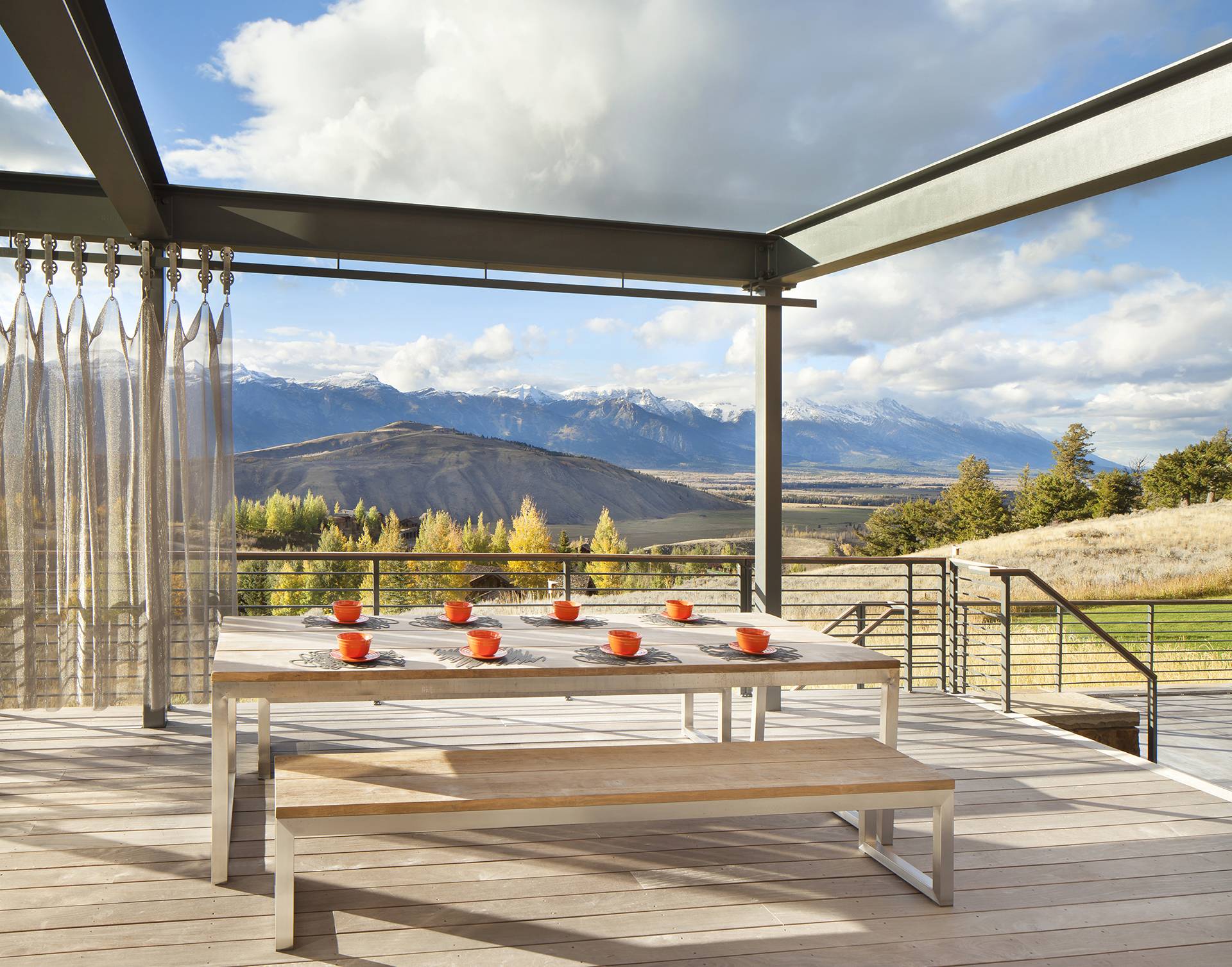 outdoor patio table on wooden balcony with view of mountains