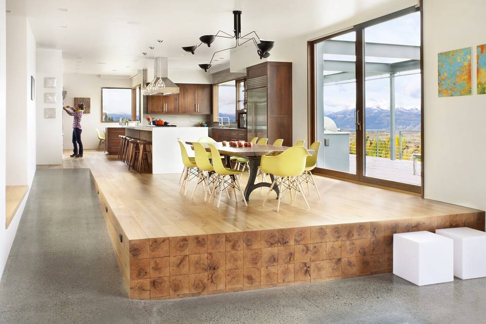 raised wooden platform with kitchen table and yellow chairs