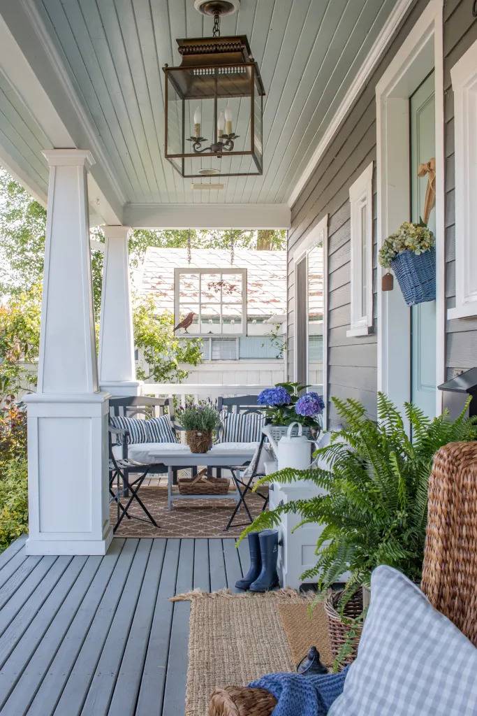 wood front porch with straw welcome mat and bistro table with chairs