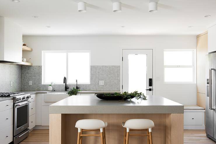 Minimal white and rift sawn oak cabinet kitchen with extra thick concrete countertops.