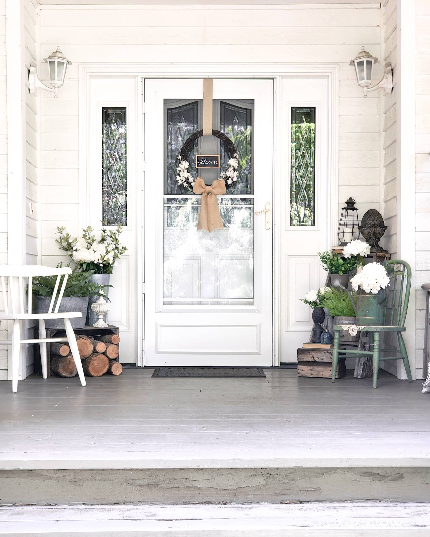 white front porch design with symmetrical chairs and plants surrounding entrance