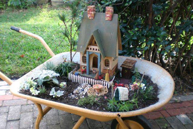 fairy garden house built inside a wheel barrow