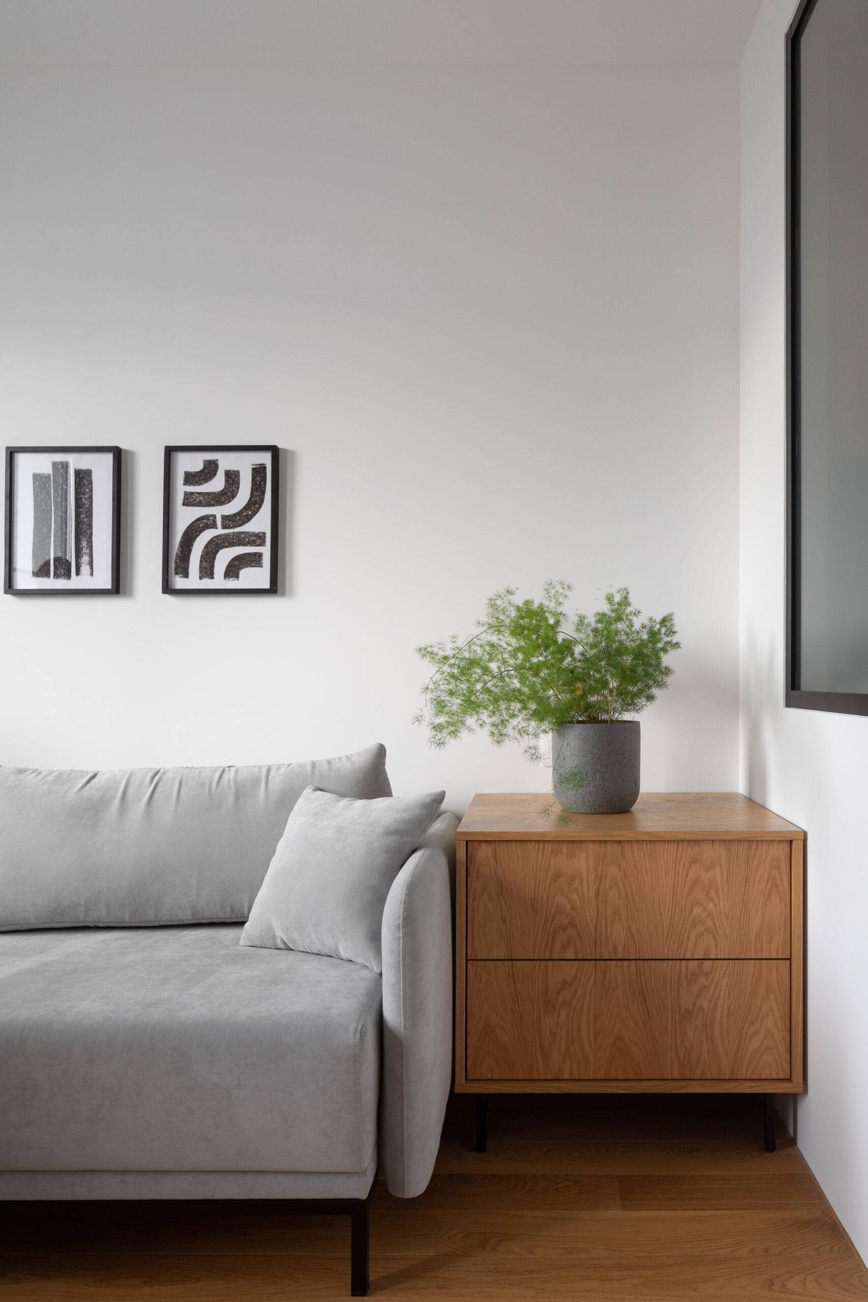 grey couch and wooden end table in bright living room space