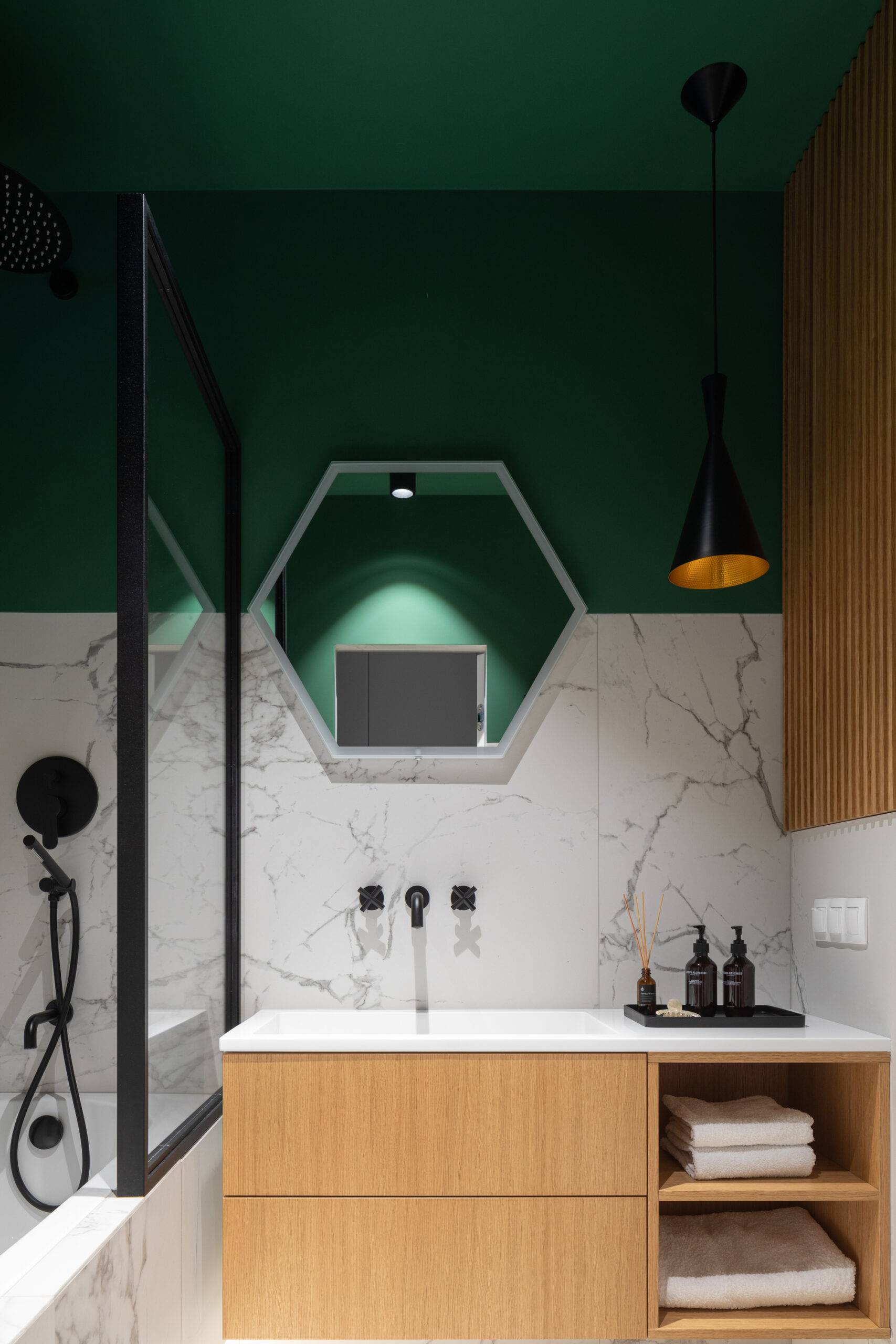 green and white bathroom with wood and black accents