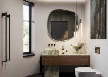bathroom with plaster walls, marble floor and vanity accents, low hanging lights and minimalist toilet