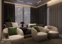 cozy white arm chairs with green accents and minimalist marble side tables in home cinema