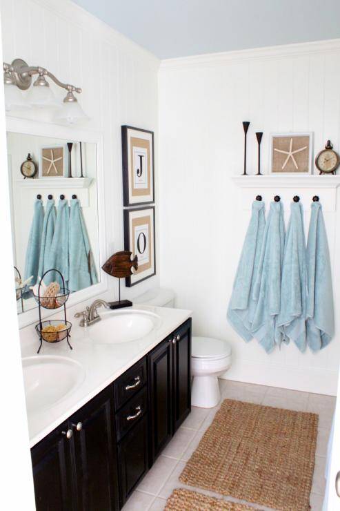 Coastal bathroom with black cabinets and painted ceiling.