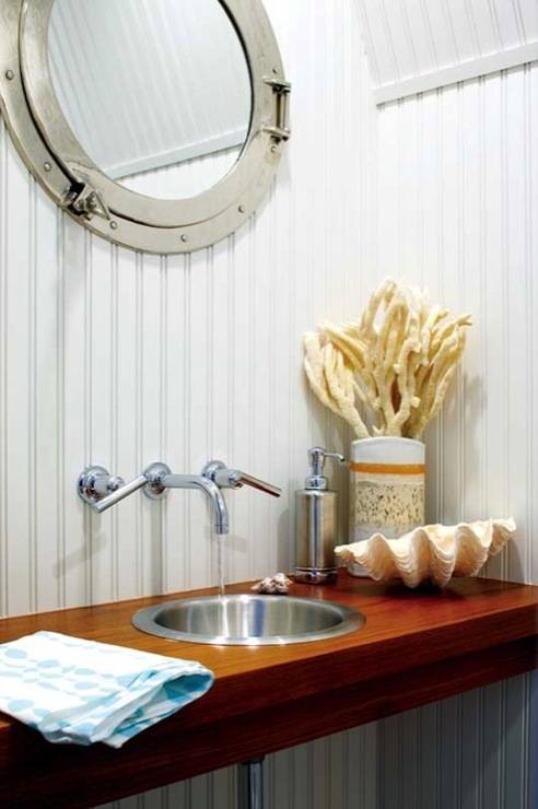 Small coastal bathroom with beadboard walls and ceiling, porthole mirror, polished nickel wall-mount faucet kit, wood floating bathroom vanity with metal sink and clam shell.