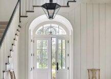 A French foyer boasts a vintage black lantern illuminating a small arched vestibule with Double doors.