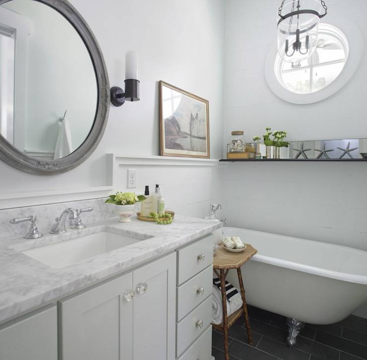 Amazing beachy cottage bathroom with vintage clawfoot tub, charcoal gray slate tiles, pale gray single bathroom cabinet vanity with marble countertop, glass knobs, pale blue walls paint color, gray vintage mirror, oil-rubbed bronze sconces and starfish.