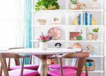 A dining area with colorful shelves and a pink rug