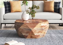 prana coffee table geometric wood shapre with white couch behind