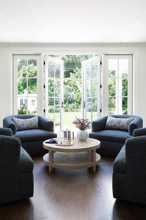 Living room features dark blue boucle lounge chairs with a gray shagreen coffee table