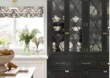 White kitchen is accented with a gorgeous black chippendale china cabinet finished with black trellis glass cabinet doors.