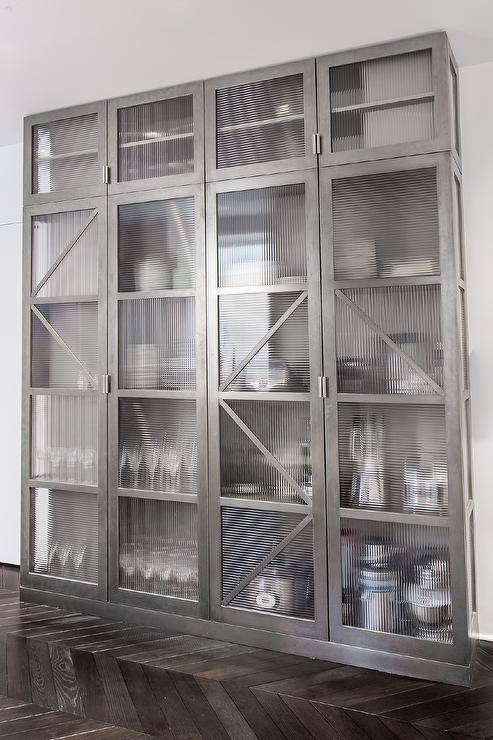 Kitchen features an industrial stainless steel China cabinet with glass doors.