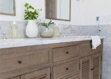 Restoration Hardware Shutter double Vanity features a gray marble countertop and a set of silver arch mirrors above sinks fitted with polished nickel faucets. Gray arabesque floor tiles invite a mosaic finish to the bathroom surface.