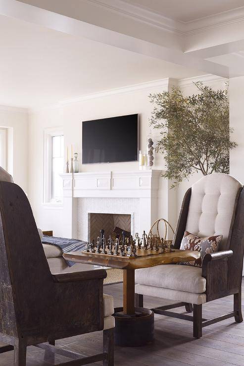 Vintage wingback chairs flank a vintage chess table.