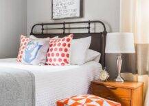 Alyssa Rosenheck - Julie Couch Interiors - Fantastic boy's bedroom features a Restoration Hardware French Académie Iron Bed dressed in red polka dot pillows and a blue stag pillow next to a single mid century modern nightstand and a red geometric pouf atop a gray grid rug.