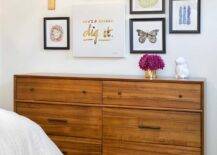 Mid-century modern wooden dresser styled in a kids bedroom features an art gallery with personalized art.