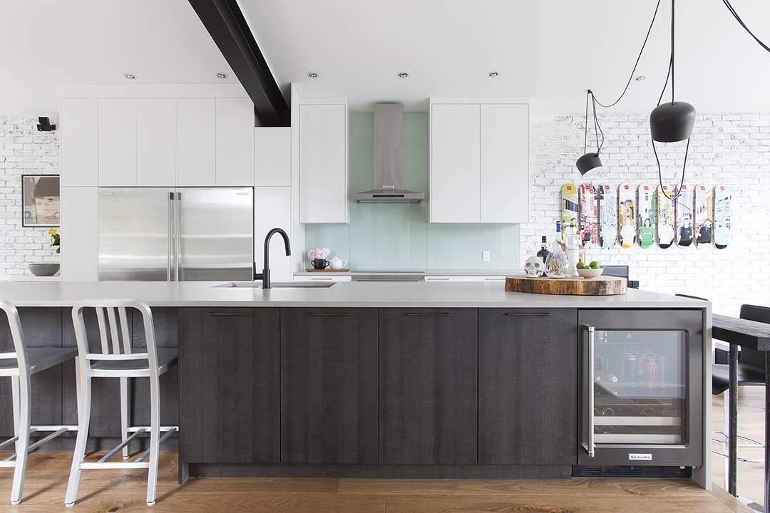 black kitchen island against white cabinets with aquamarine backsplash