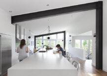 woman and child in modern white kitchen with black steel beam framing the room