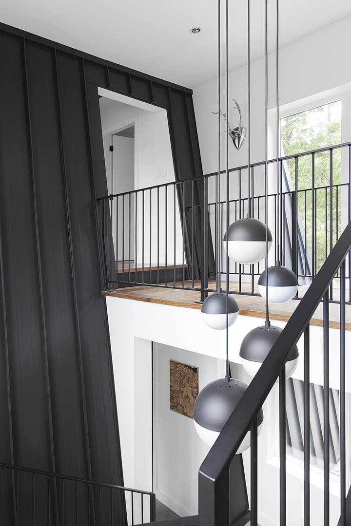 staircase up to black accent wall with a mirror