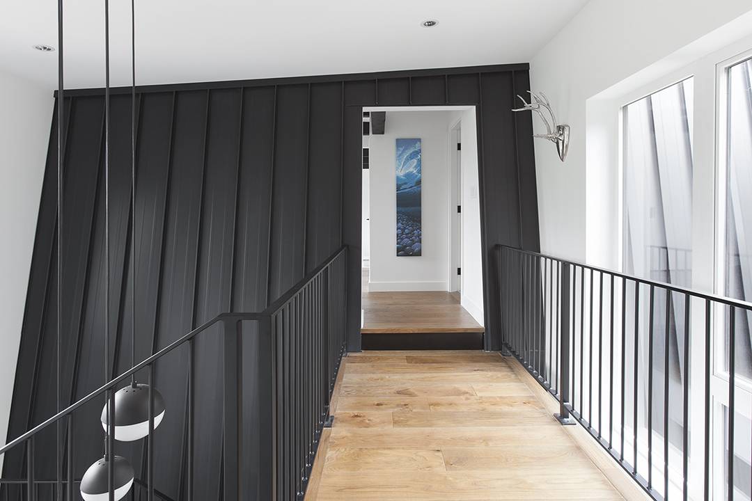 a hallway with a wooden floor and black walls.