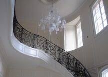 Amazing 2-story foyer with winding staircase, iron stair railing and crystal chandelier.