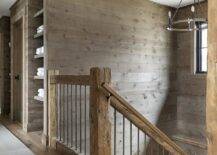 Country staircase features rustic wooden posts, a gold railing and brown oak plank walls.