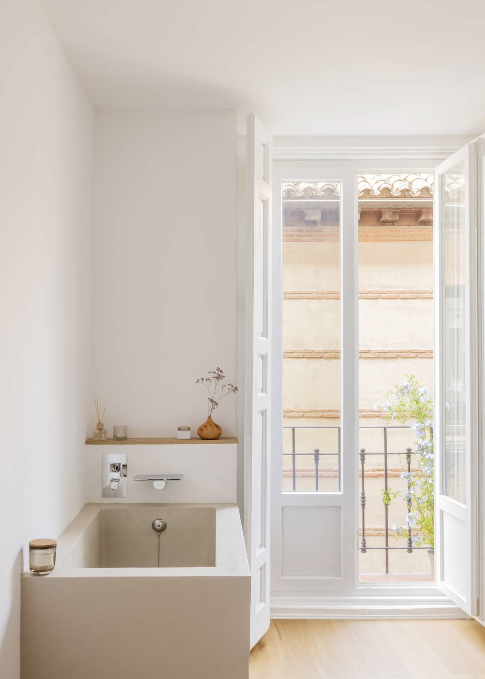 white bedroom with open balcony doors and japanese stone bathtub