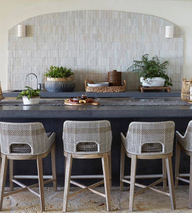 BLU Home Tapestry Bar & Counter Stools are placed at a black leathered countertop accenting a black island topped with a black table runner.