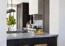 Modern kitchen features a dark brown plank breakfast bar with gray marble top and wooden tractor stools.