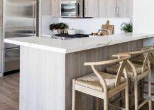 Kitchen features a brown kitchen peninsula breakfast bar with tan wishbone stools that boast abaca seats