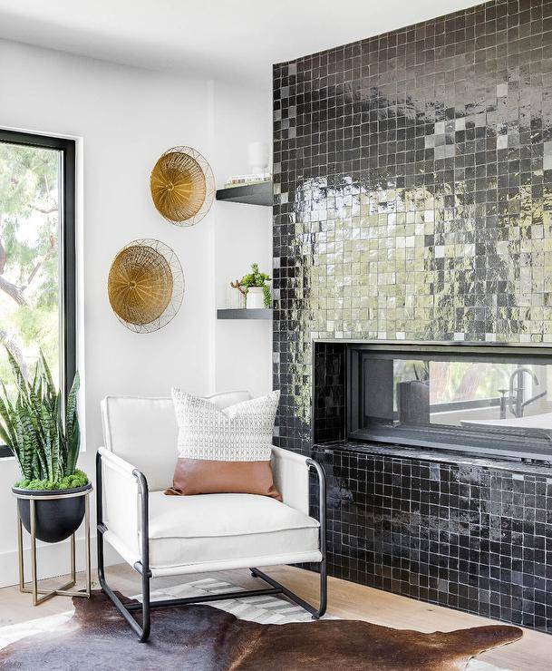 Living room features a modern fireplace with black glazed grid tiles and a white accent chair.