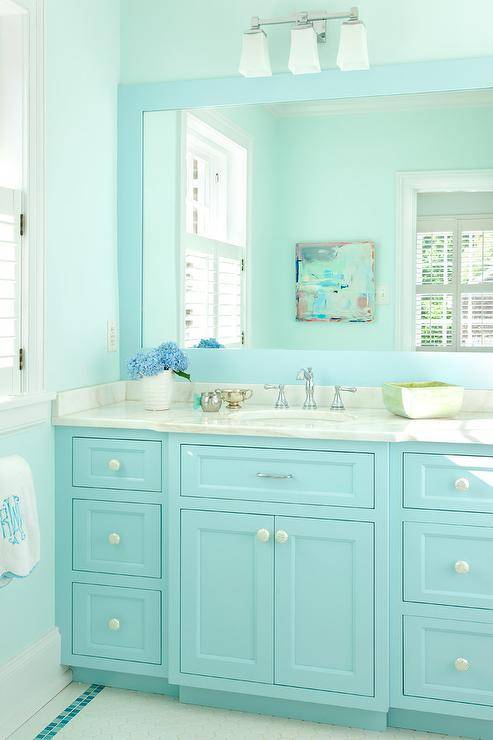 Turquoise kid's bathroom features a turquoise blue bath vanity topped with gray and white marble placed under a turquoise blue framed mirror illuminated by a Restoration Hardware Dillon Triple Sconce.