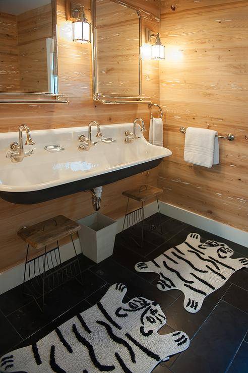 kid's cottage-style bathroom with white trough sink, wood paneled walls and animal print rugs