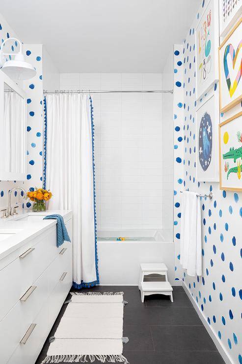 white kids bathroom with blue polka dots and bright blue accents