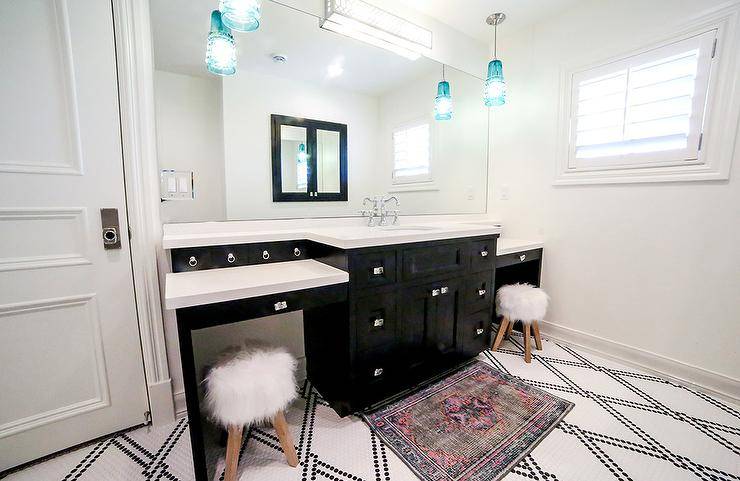 Chic black and white contemporary kids' bathroom features a black and pink rug placed on black and white penny floor tiles