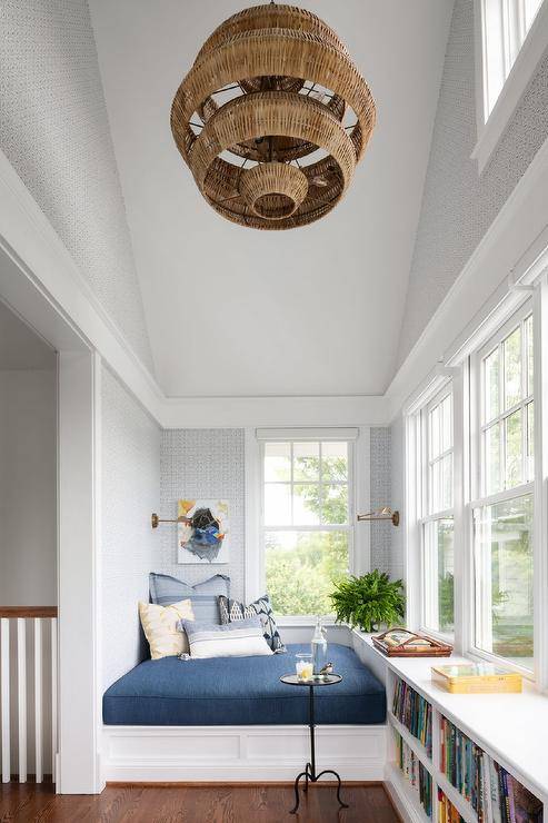 Staircase landing features a built in reading nook with blue cushion and bookshelves.