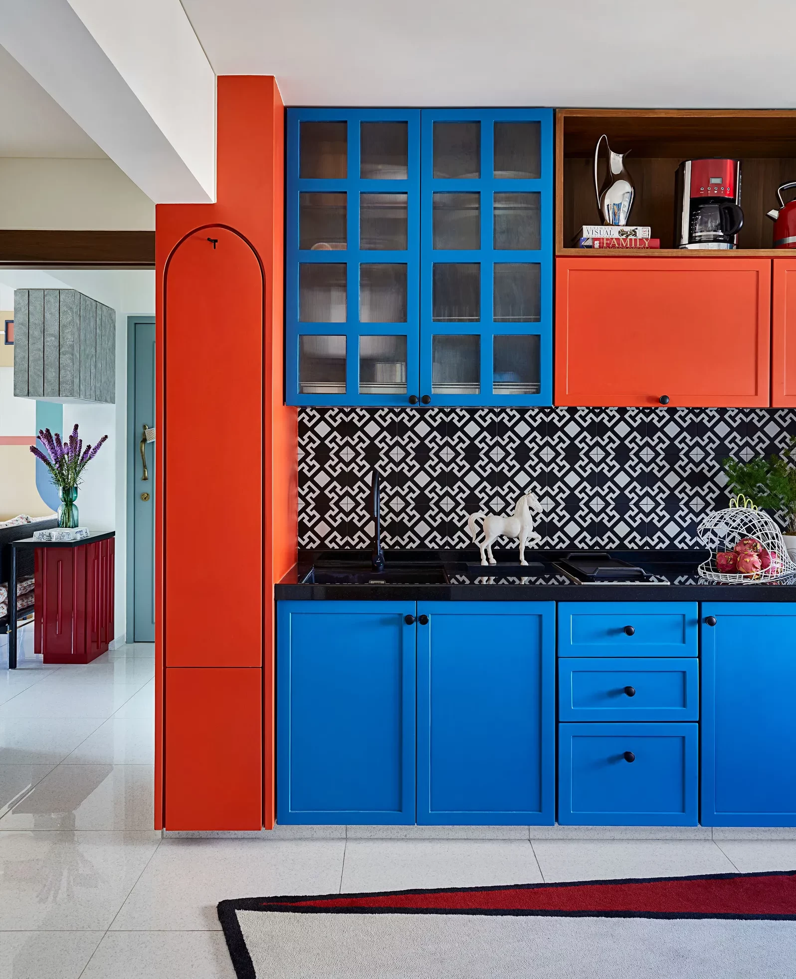 electric blue and red kitchen cabinets with black accents, white & black patterned backsplash
