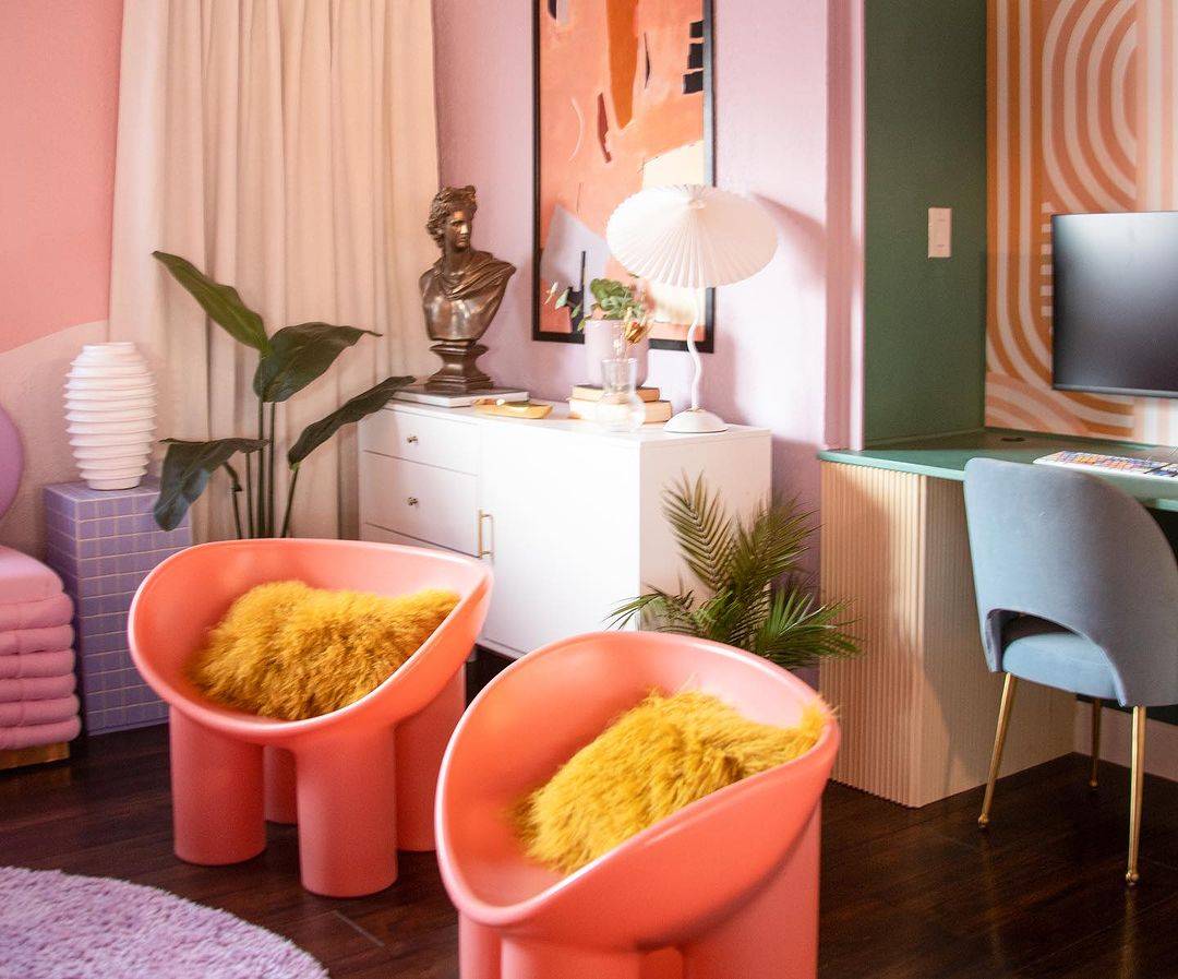 retro pink bucket chairs in brightly colored room with pink accents