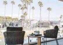 Bedroom balcony boasts modern black rope chairs and a round wooden accent table.