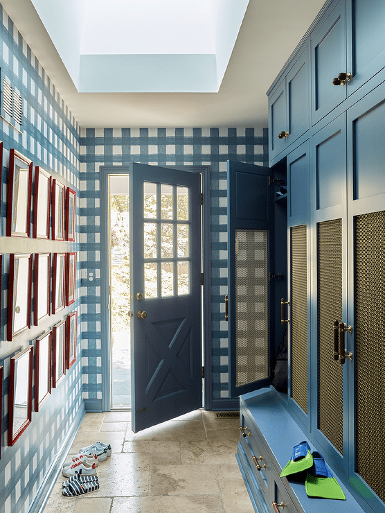 Mudroom features blue lockers with brass lattice doors, blue gingham wallpaper and a mudroom skylight.