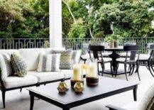 White, black and yellow covered patio design features a black and white outdoor sofa with yellow and black pillows, a black Klismos coffee table and a yellow garden stool.