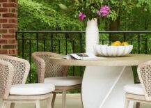 Patio features light brown rope chairs with a white twist table atop light gray pavers.