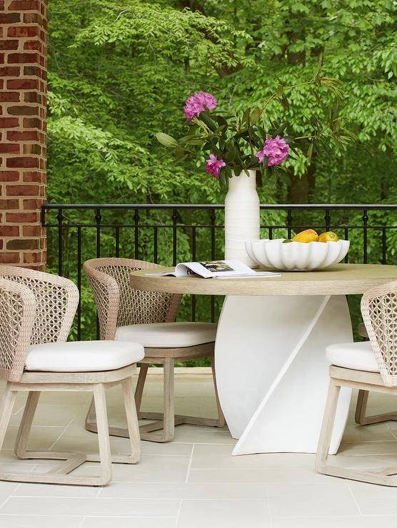 Patio features light brown rope chairs with a white twist table atop light gray pavers.