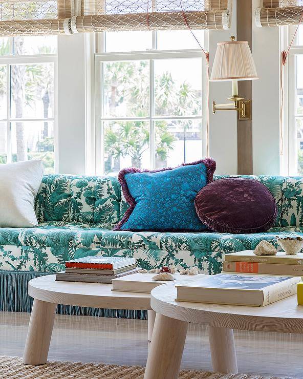 Living room features a blue tufted sofa with blue fringe, accented with purple and blue pillows and round coffee tables.